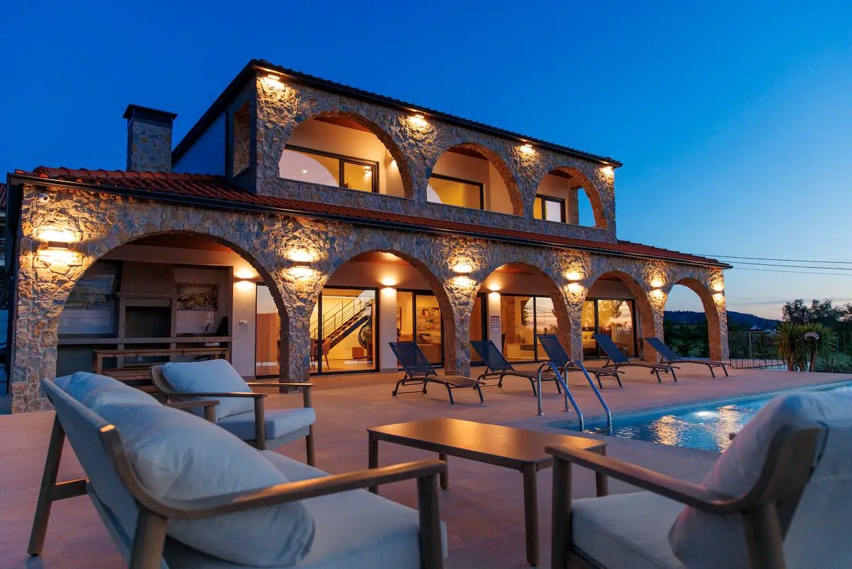 A villa iluminada ao anoitecer